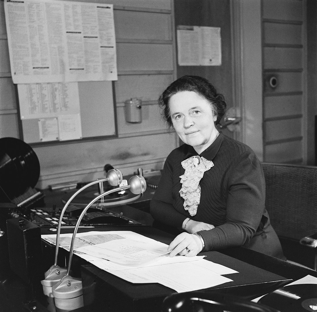 Female field coordinator wearing a headset holding a clipboard on a broadcast set