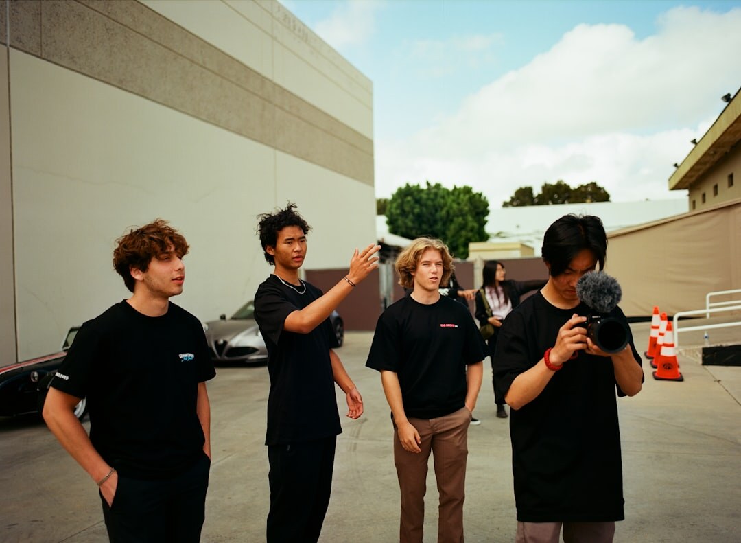 Team of broadcast technicians and field coordinators standing beside a satellite production van