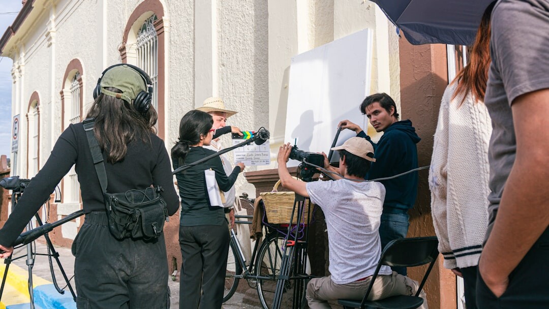 Broadcast crew filming a live outdoor news report with camera and microphone